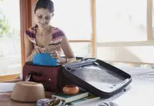 Woman with an open suitcase on the table.